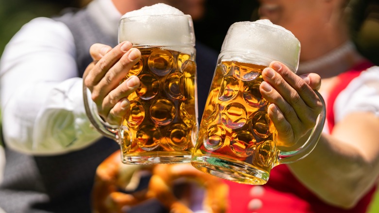 Two people holding up beer glasses