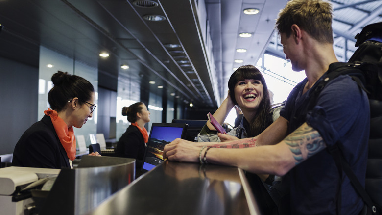 Couple talking to airport staff