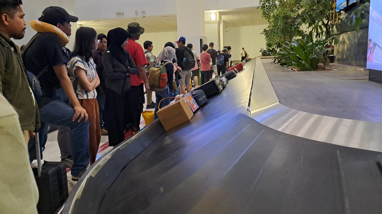 People waiting at luggage carousel