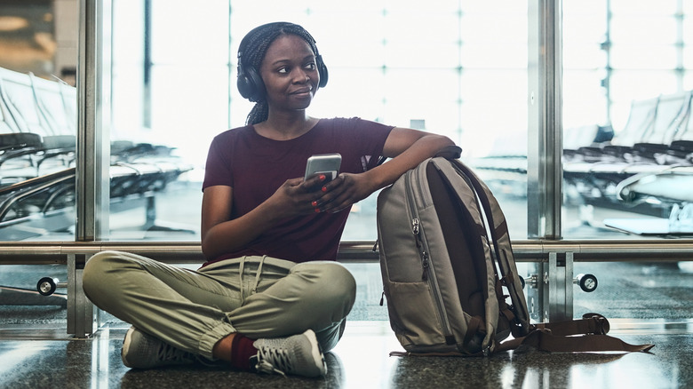 Girl using headphone at the airport