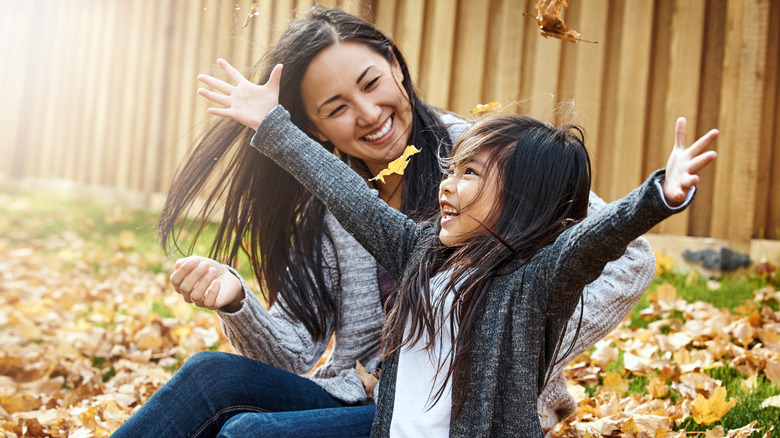 Mother and daughter playing in leaves