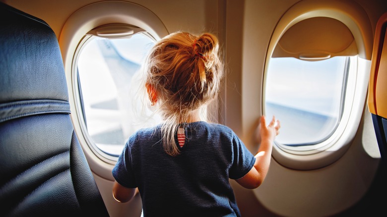 Little kid looking out plane window