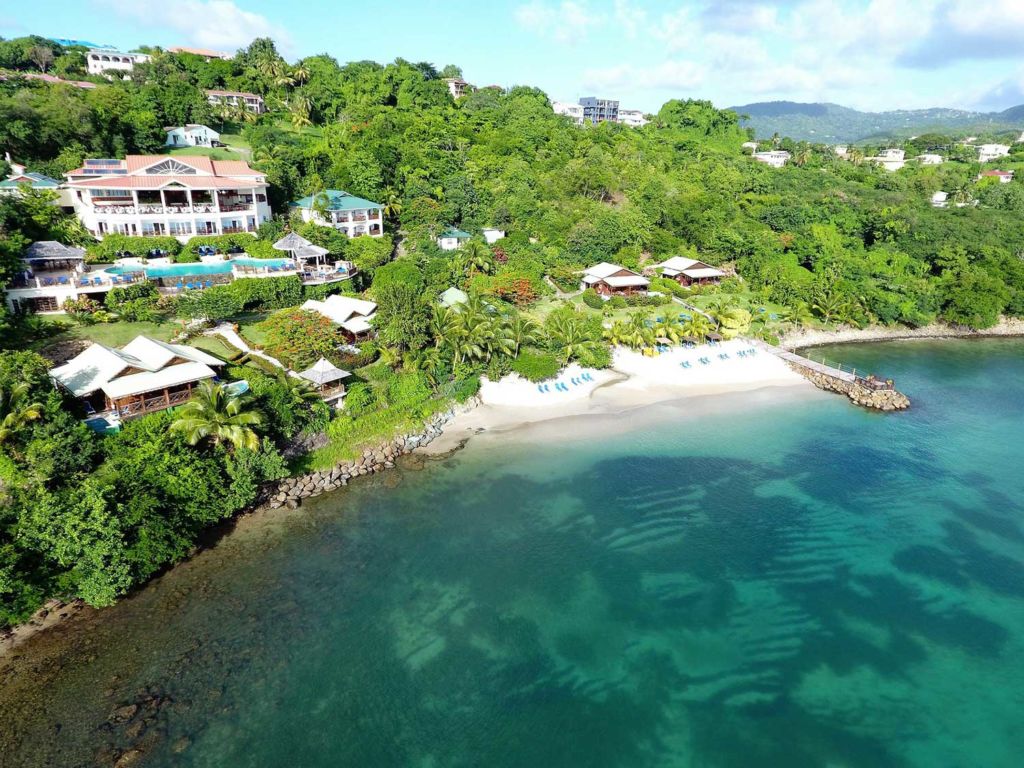 A small cove of ocean water next to a resort.