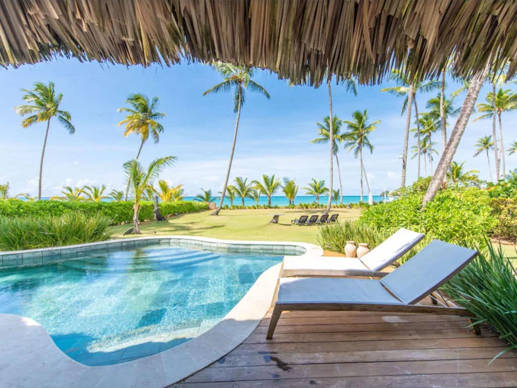 A resort style lounge area outdoors by a beach.