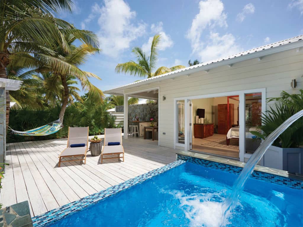 Two lounge chairs on the deck by a pool and resort condo.