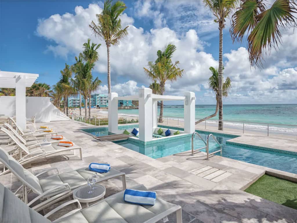 An outdoor lounge area by a pool and a beach.