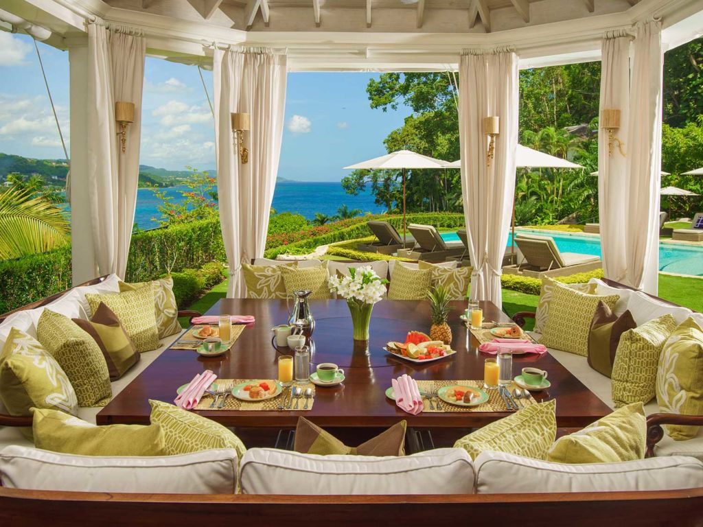 An outdoor breakfast nook under a pagoda with curtains