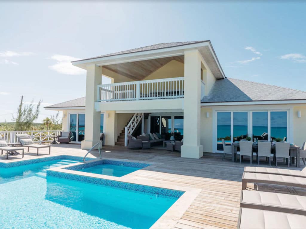 A beach house with a pool and jacuzzi.