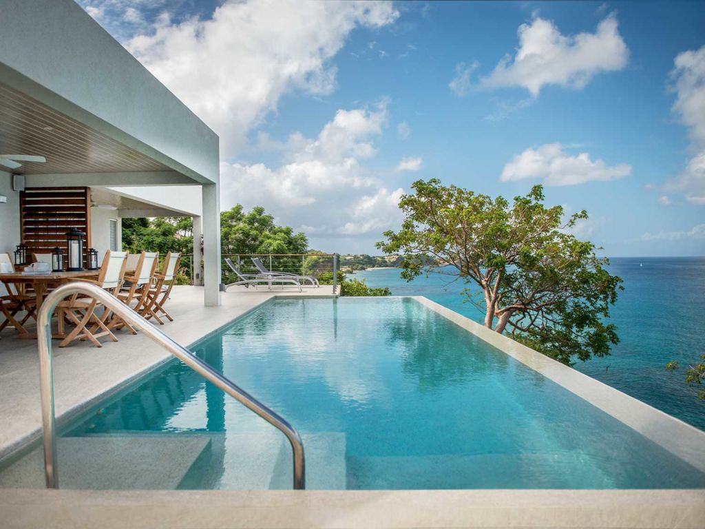 A pool at a resort overlooking the ocean.