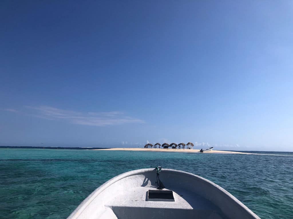 A small boat sailing towards an island.