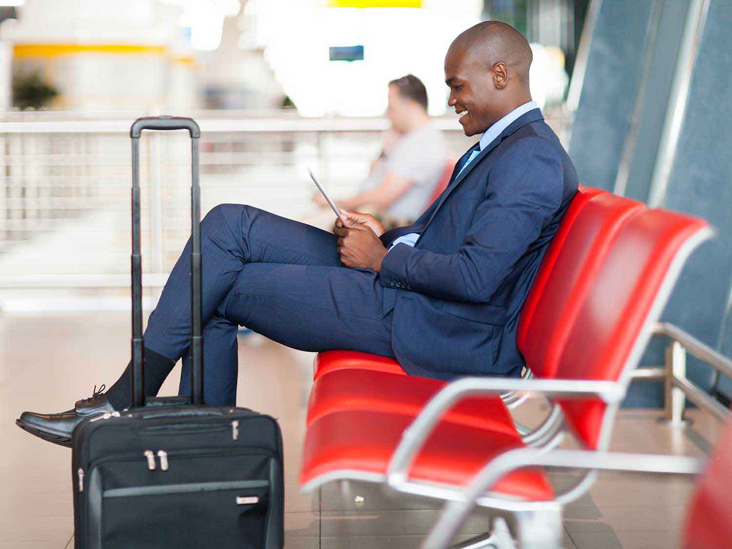 Man looking at his smart device in an airport