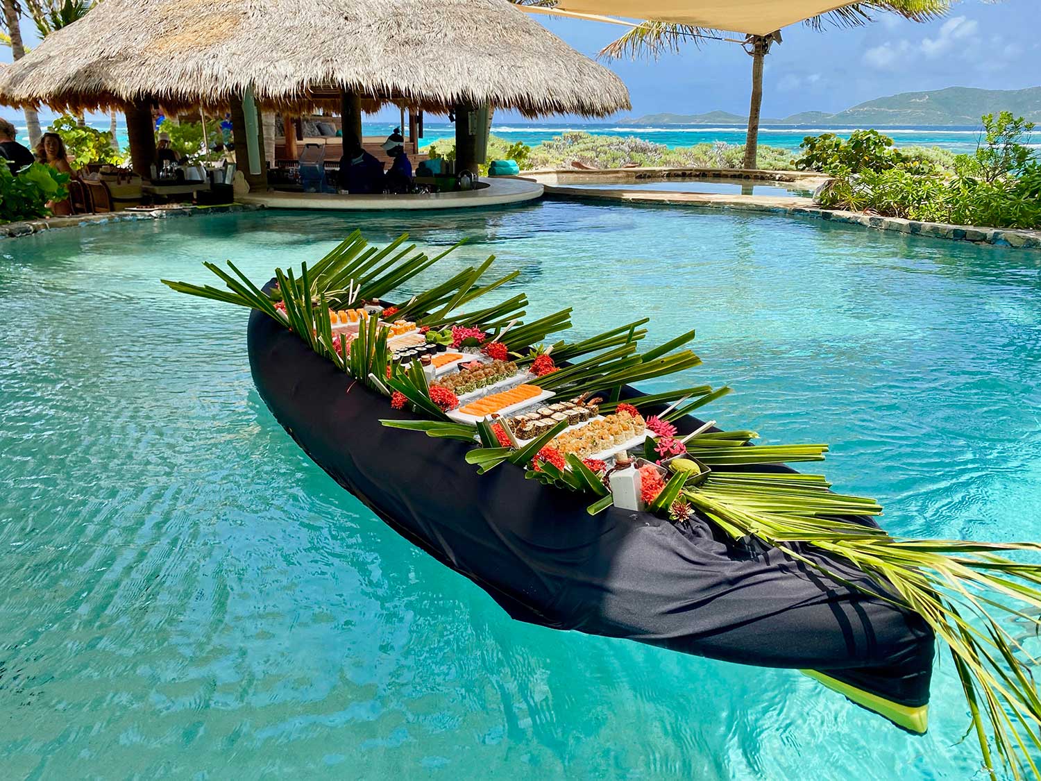 A large sushi boat in a pool.